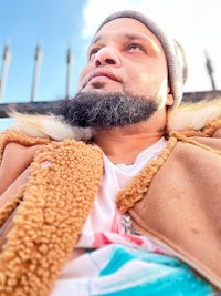 a man with a beard sitting on a bench